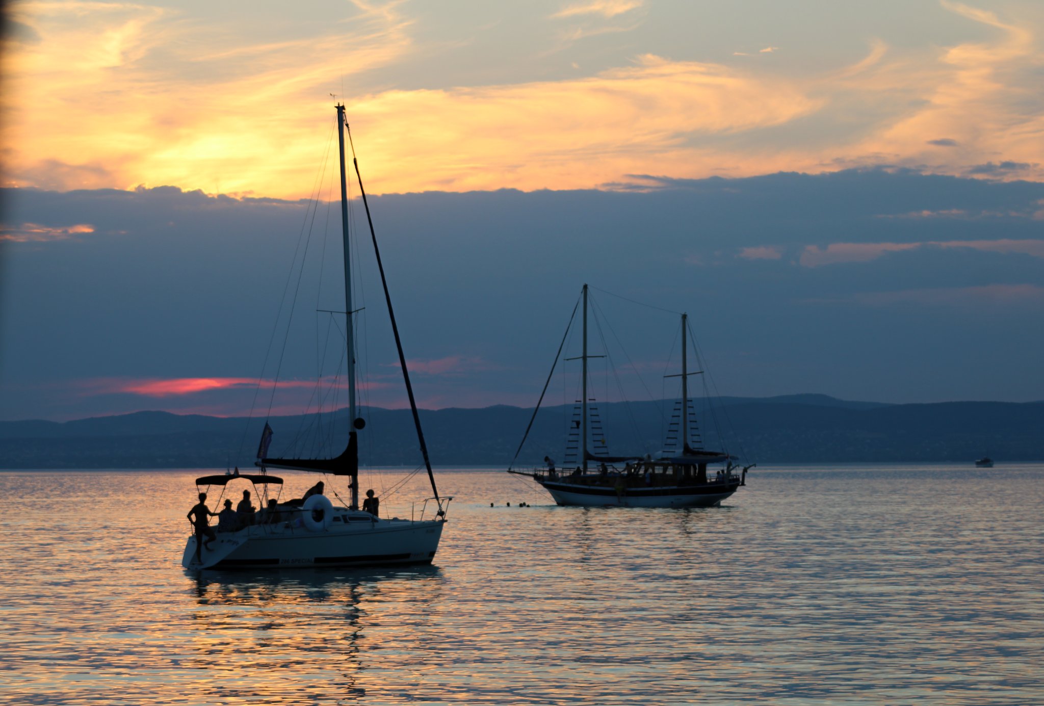 Travel with family. Two boats on the lake in the sunset.